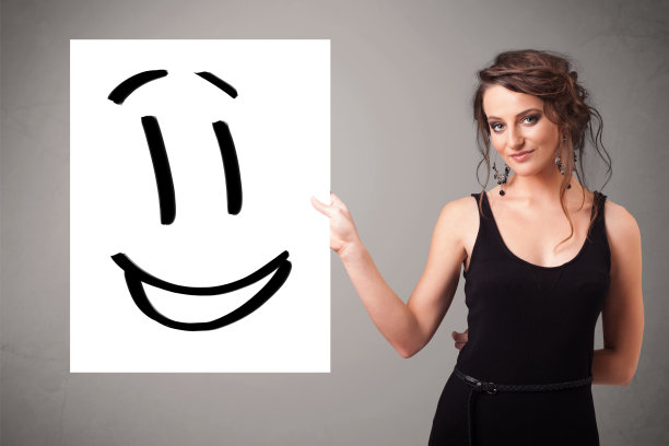 年轻女子拿着笑脸画图片下载