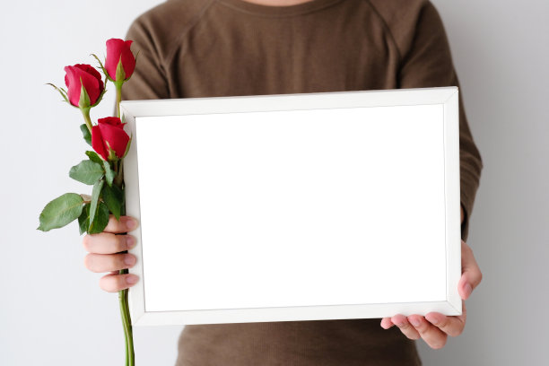 情人节的背景，男人手拿红玫瑰和空白的白色木框架站在白色的背景图片下载