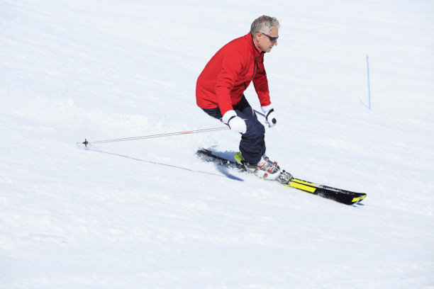 业余冬季运动高山滑雪。男子滑雪者在阳光明媚的滑雪场滑雪。高山雪景。图片下载