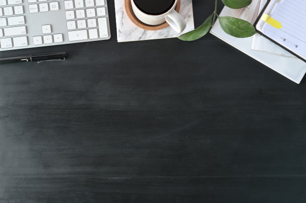 平躺俯视图办公桌。工作空间配有键盘和黑色木桌上的办公用品，复制空间概念。图片下载