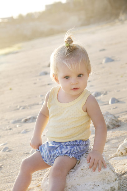爽快的宝宝户外肖像在海滩，自然的背光照片图片下载