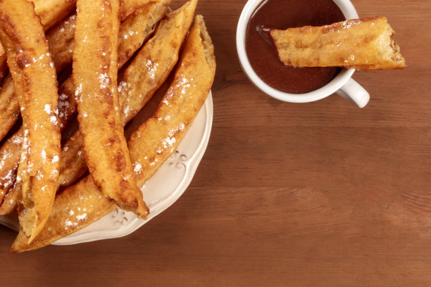 这是一张传统的西班牙波拉斯和热巧克力的特写照片，典型的马德里周日早餐，在一个黑色的乡村木制背景和文字的地方从上面拍摄图片下载