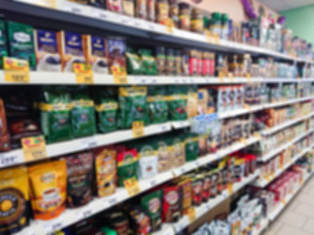 模糊抽象的形象。杂货店货架上的货物。咖啡，咖啡饮料和茶图片下载