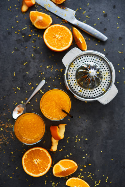 俯视图的新鲜橙汁在高脚杯和柑橘挤压在黑暗的混凝土背景图片下载