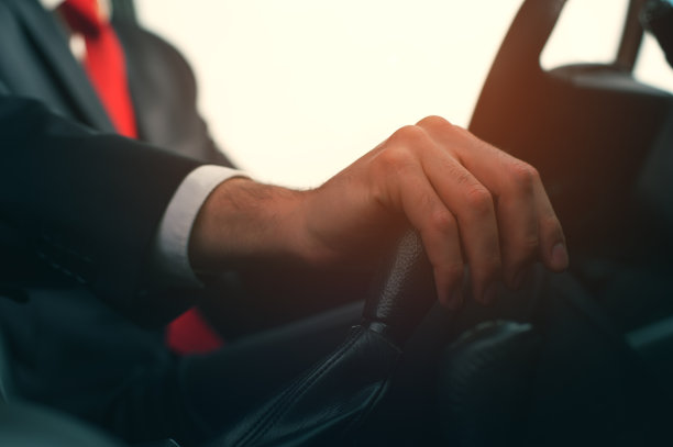 特写-商人在车轮的新汽车图片下载