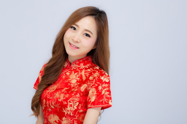 美丽的肖像快乐的中国新年年轻的亚洲妇女穿着旗袍微笑手势祝贺和问候孤立在白色的背景，节日和庆祝的概念。图片下载