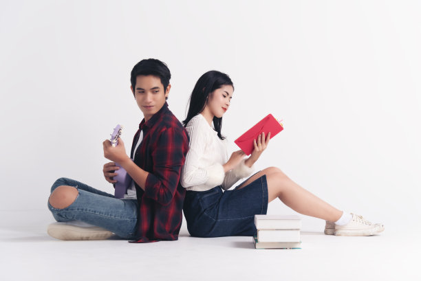 美丽的年轻夫妇在家里，享受一起度过时间庆祝圣瓦伦丁节，手握礼物，自拍与手机，幸福和爱的运动。图片下载