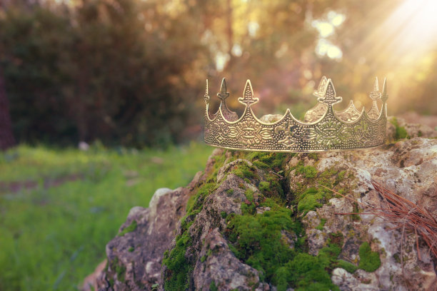 神秘而神奇的银王皇冠照片上的石头覆盖着苔藓，在英格兰的树林或田野景观中闪耀着光芒。中世纪的概念。图片下载