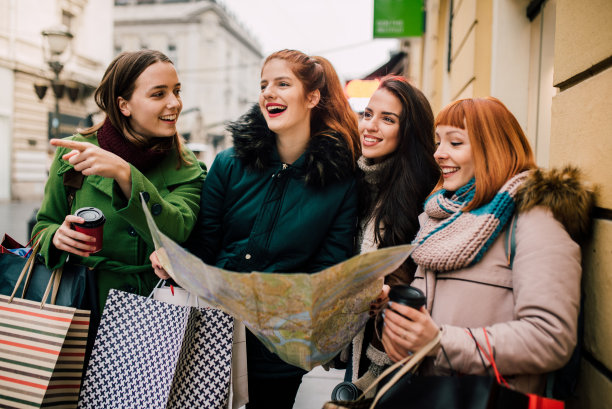 拿着地图和购物袋的女孩们图片下载