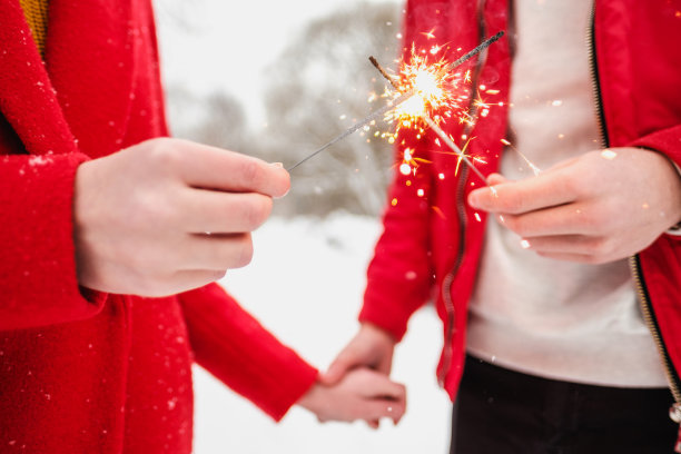 烟花和烟花在一个男人和一个女人的手中特写。图片下载