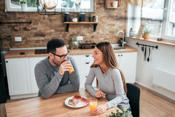 一张年轻夫妇在家吃早餐的照片。图片下载