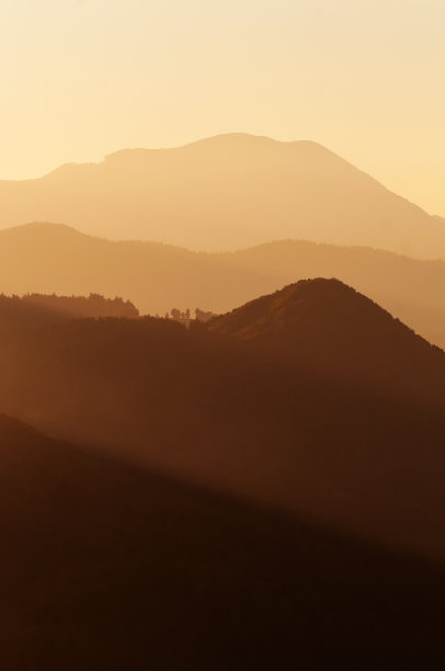 一层层的山丘和山脉在美丽的夕阳的光芒下图片下载