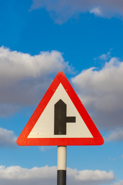 道路分岔口，右侧标志牌，背景是蓝天白云。概念：道路或方向的改变图片下载