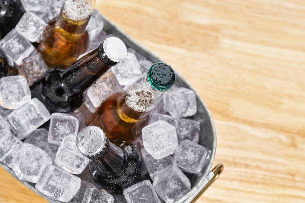 俯视着摆放在木桌上镀锌桶里的各式各样的啤酒瓶图片下载