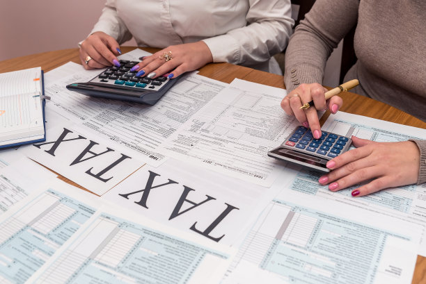 女性手上有计算器和1040表格图片下载