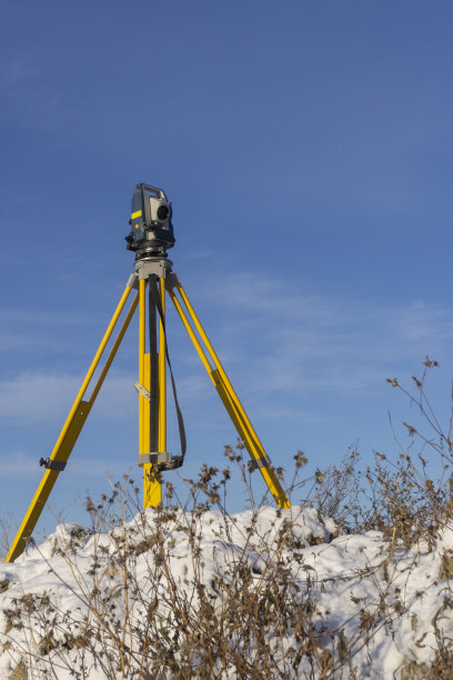 测量员在冬季为建筑工地的地籍工作进行地形测量图片下载