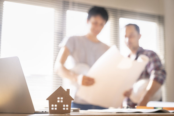 建筑师团队在办公室讨论房屋或建筑物的问题，平面图仅为库存照片而伪造。图片下载