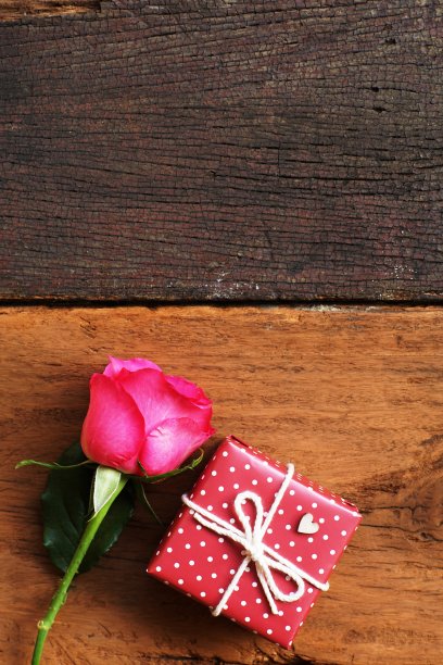 优雅的粉色玫瑰，花瓣装饰的礼盒，木材背景上自然柔和的灯光，美丽的情人节背景概念，复制空间图片下载