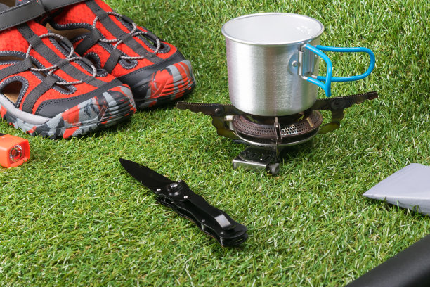 在绿茵茵的草地上，躺着一些在极端条件下适合徒步旅行和休闲旅游的东西图片下载