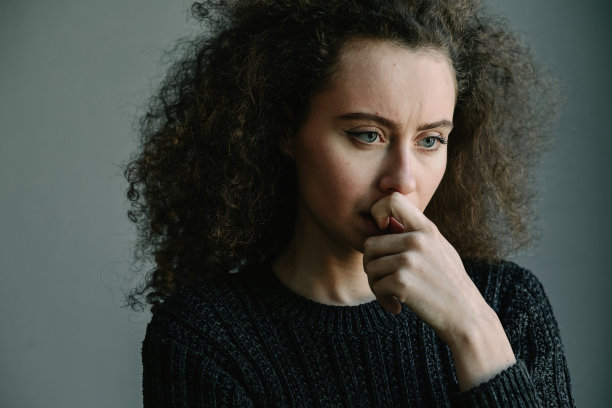 近距离观察患有抑郁症和暴食症的青少年独自站在灰色房间里。患有抑郁症和暴食症的精神问题。黑白照片。图片下载