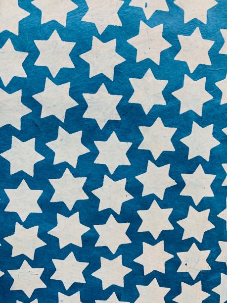 抽象的白色星星在蓝色的纸背景图片下载