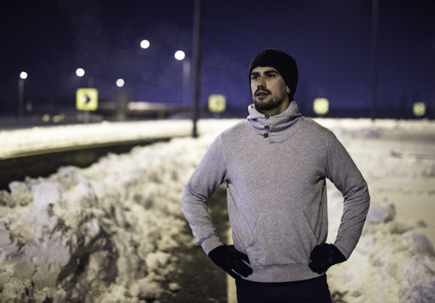 在一个寒冷的冬夜慢跑后休息的运动的年轻人。图片下载