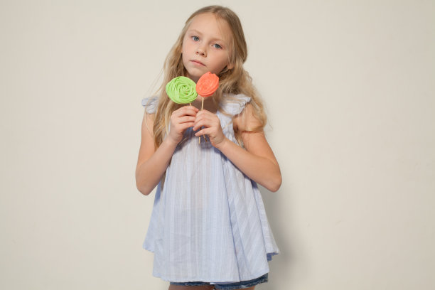 一个女孩手里拿着两根棒棒糖图片下载