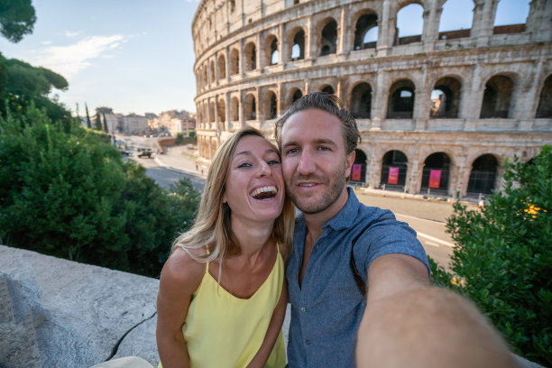 一对年轻夫妇在罗马享受意大利旅行，在著名的罗马斗牛场前拍照图片下载