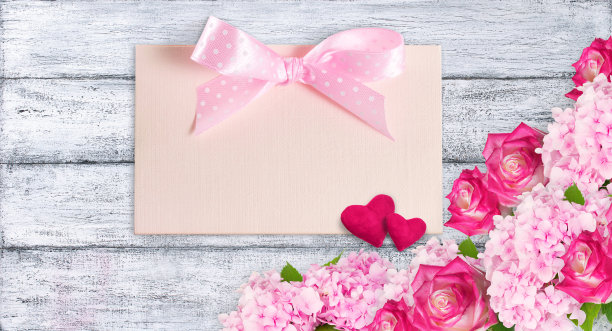 粉红色的玫瑰和绣球与心和卡片的情人节破旧的木板背景。图片下载