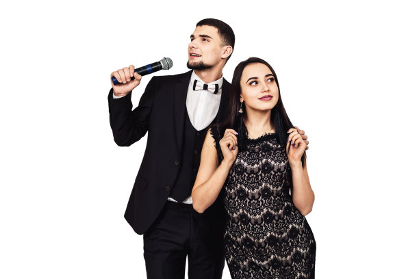 一个穿着黑色西装，手里拿着麦克风的大胡子男人和一个穿着黑色晚礼服的漂亮女孩图片下载