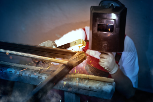 工人戴着防护面罩焊接金属图片下载