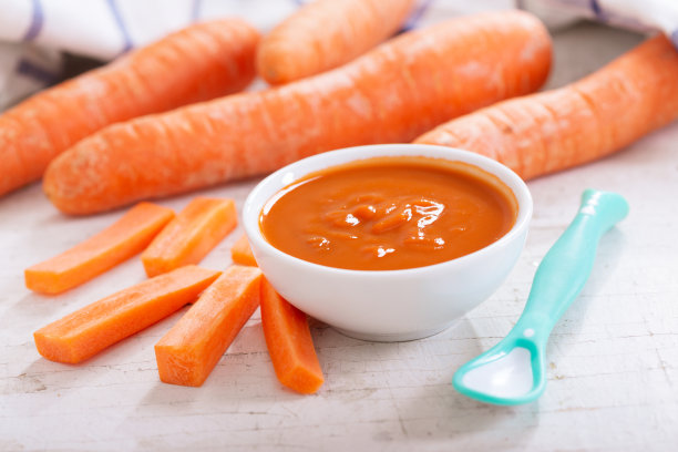 婴儿食品。一碗胡萝卜泥和烹饪用的配料素材图片