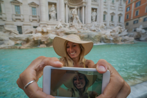 在罗马旅游的游客在许愿池边用手机自拍;意大利图片下载