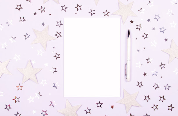 笔记本和钢笔在白色的背景和星星。图片下载