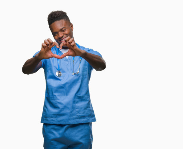 年轻的非洲裔美国医生男人在孤立的背景穿着外科医生制服微笑在爱显示心形符号和形状的手。浪漫的概念。图片下载