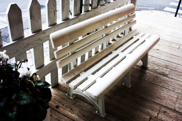 路边的人行道上有一条白色长凳，上面放着水平的塑料含片图片下载