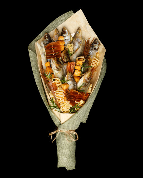 一束由不同品种的盐渍鳕鱼、干鱿鱼片和其他鱼组成的黑色背景图片下载