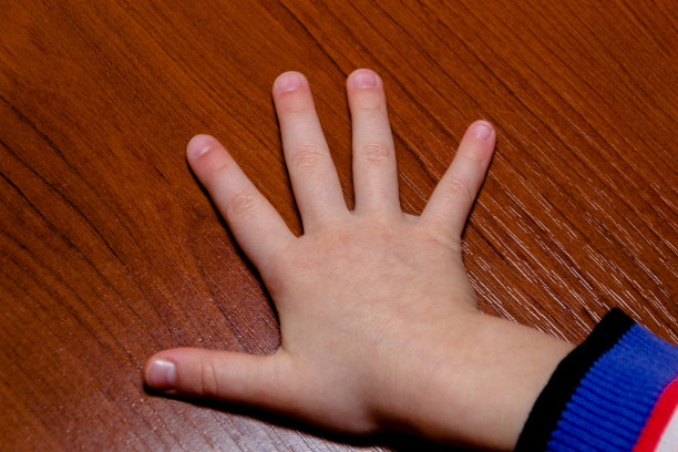孩子的手显示五个手指孤立的木材背景。女孩图片下载