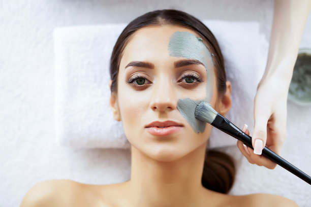 美容和护理。美丽的年轻女孩在水疗沙龙。面部程序。面罩。纯美肌肤的女孩。高分辨率图片下载