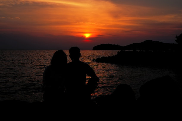 剪影幸福的恋人在夕阳时分。图片下载