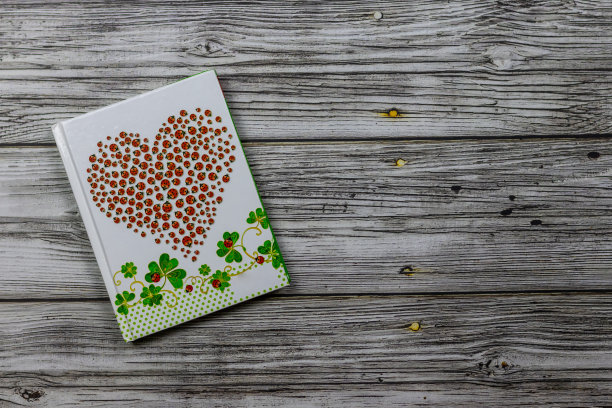 红心瓢虫笔记本。在木制背景，上面的照片。节日,情人节。附有副本空间的明信片图片下载