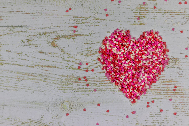 用五颜六色的小心做成的大心。在木制背景上，照片散焦。情人节的节日。有拷贝空间的情人节卡片。图片下载