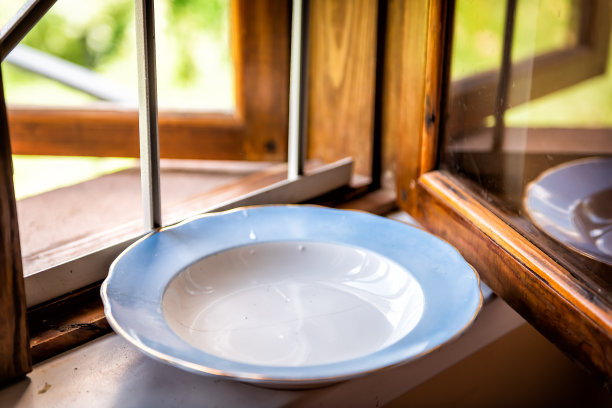 在乌克兰乡间避暑别墅的花园旁，窗台上的空干净的洗过的盘子图片下载