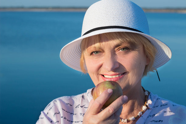 快乐的退休老人咬苹果显示白牙齿图片下载