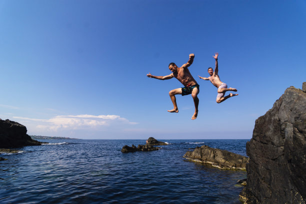 两个年轻人从悬崖上跳入海里图片下载