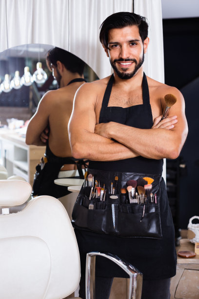 男专业化妆师拿着刷子站在沙龙里图片下载