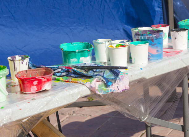 画笔和铅笔在街道上溅满颜料的硬纸板上图片下载