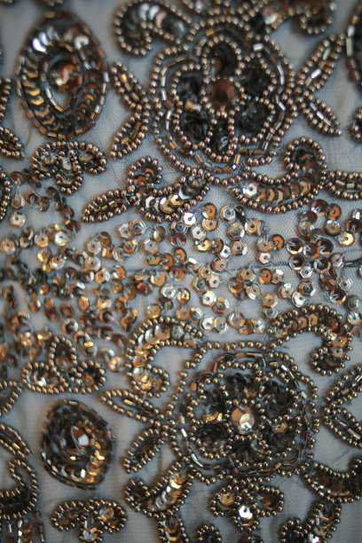 灰色礼服上复杂的织物珠饰和亮片的特写细节图片下载