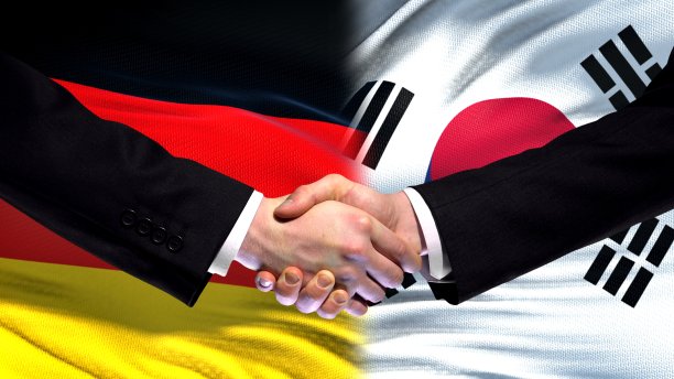 德国和韩国握手，国际友谊，国旗背景图片下载