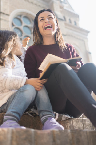 星期天，母亲和女儿在教堂前朗读这本书中的故事图片下载